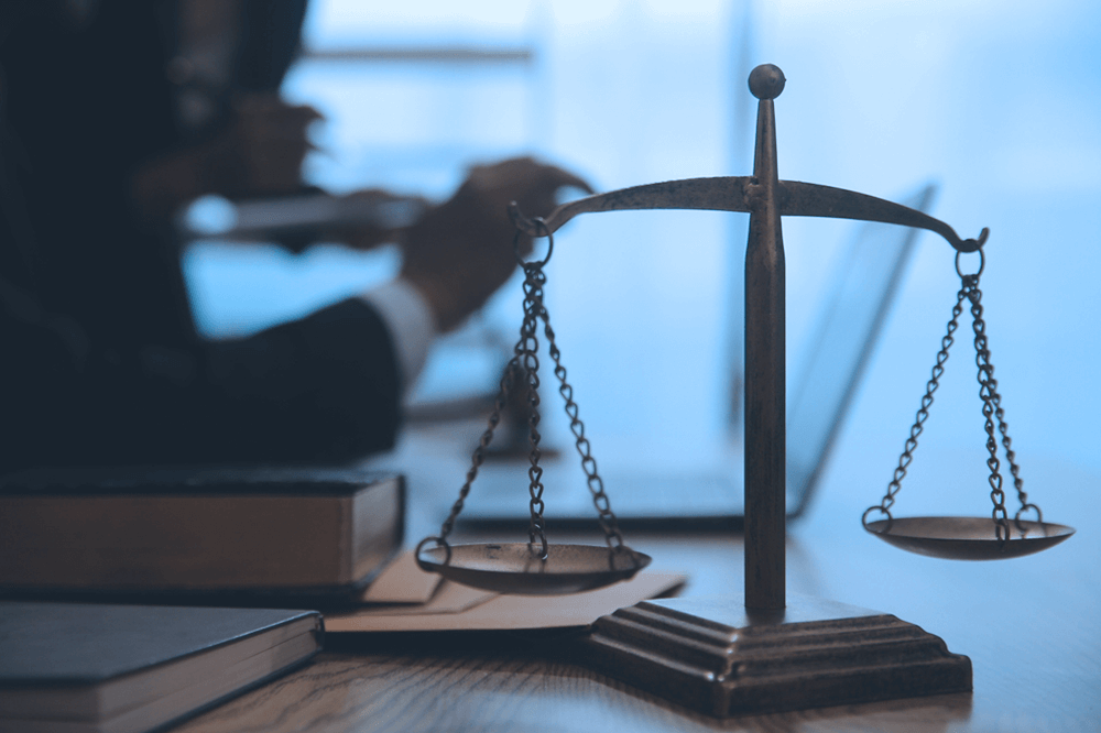 Scales of justice on a desk with legal books, symbolizing analysis of UAE tax laws by the former Chief Justice