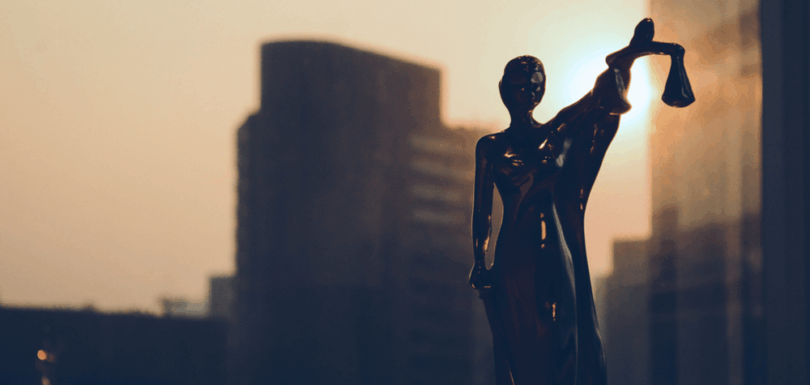 Statuette of Lady Justice against a city skyline, representing the legal principle of divisibility in an arbitration award as established by the Court of Cassation.