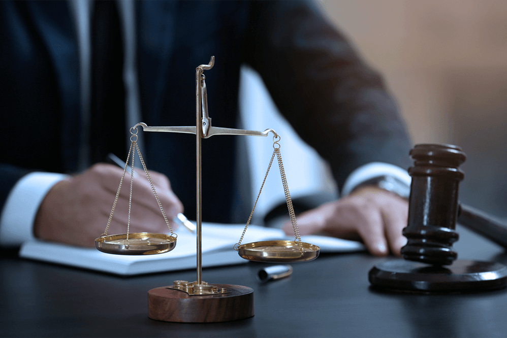 Lawyer writing at desk with scales of justice and gavel during arbitral proceedings in UAE