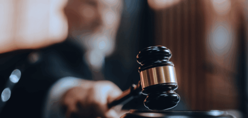 Judge’s hand holding a gavel symbolizing the balance between mercy and justice in court decisions