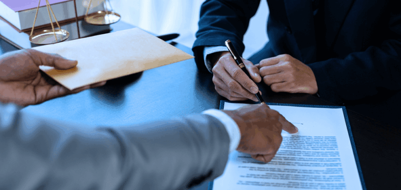 Lawyer signing a contract agreement in an office, symbolizing legal proceedings involving forged documents