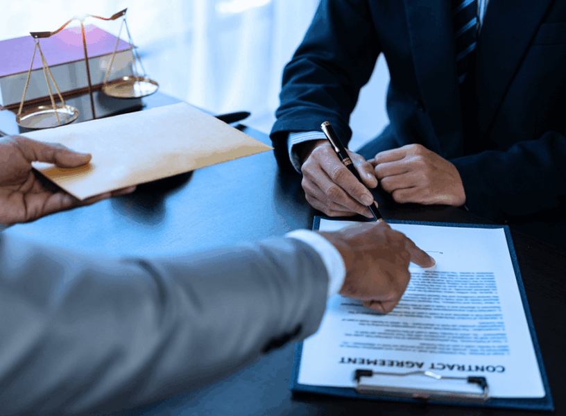 Lawyer signing a contract agreement in an office, symbolizing legal proceedings involving forged documents