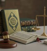 لقرآن الكريم وكتب الشريعة الإسلامية ومطرقة القاضي وميزان العدالة الذهبي على مكتب، يرمزون لتكامل الشريعة مع العلوم القانونية